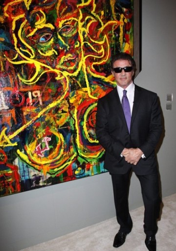 Sylvester Stallone poses with one of his paintings at Miami Basel, Dec. 2, 2009. Courtesy BigPicturesPhoto.com