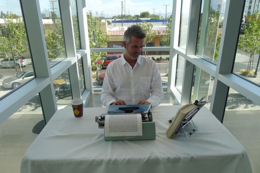 Tim Youd re-typing Tom Wolfe's "The Right Stuff" in Lancaster, California at the Lancaster Museum of Art and History, August 2013. Photo: Coagula Archives.