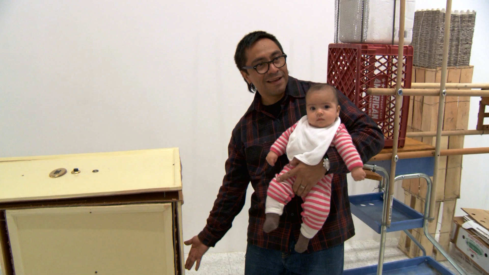 Abraham Cruzvillegas with his daughter installing The Autoconstrucción Suites at the Walker Art Center in Minneapolis, Minnesota. Production still from the series ART21 Exclusive. © ART21, Inc. 2016. Cinematography: Mark Falstad.
