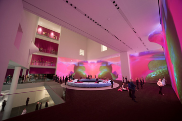 Installation view of Pipilotti Rist’s Pour Your Body Out (7354 Cubic Meters) at The Museum of Modern Art, Multichannel video projection (color, sound), projector enclosures, circular seating element, carpet, 2008, courtesy the artist, Luhring Augustine, New York, and Hauser & Wirth Zürich London.