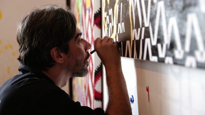 Eli Sudbrack of assume vivid astro focus works on his painting “Cyclops Small Dick Donut Hat Three Boobs” (2014) in his Queens, NY studio. Production still from the series ART21 "Exclusive." © ART21, Inc. 2014. Cinematographer: John Marton.
