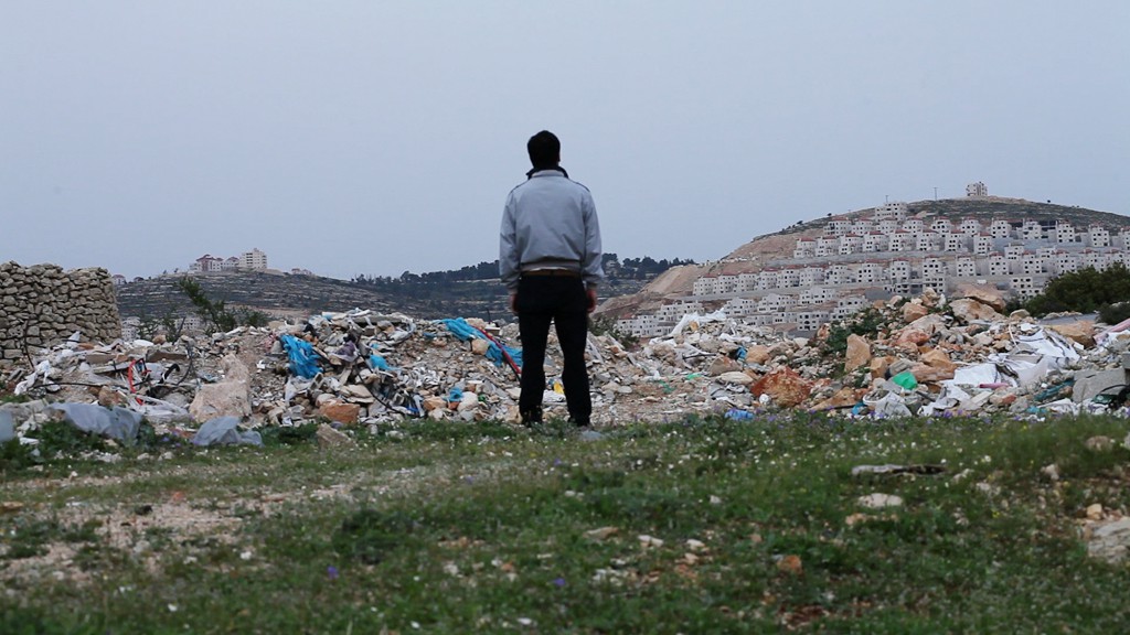 Figures 20-22: Dreams and nightmares. Above video still from The Zone, a figure stands amongst garbage and ruin looking out at a new Palestinian development disconcertingly resembling a settlement. Below, muted horizons, a series of new home devlopments have been named after Palestinian cities that residents of the West Bank are not allowed to enter without a permit, this one is Haifa Buildings, similarly an empty billboard on the Beir Zeit road with the distance to Jerusalem indicated. From the series Desire and Disaster – The Zone 2011.