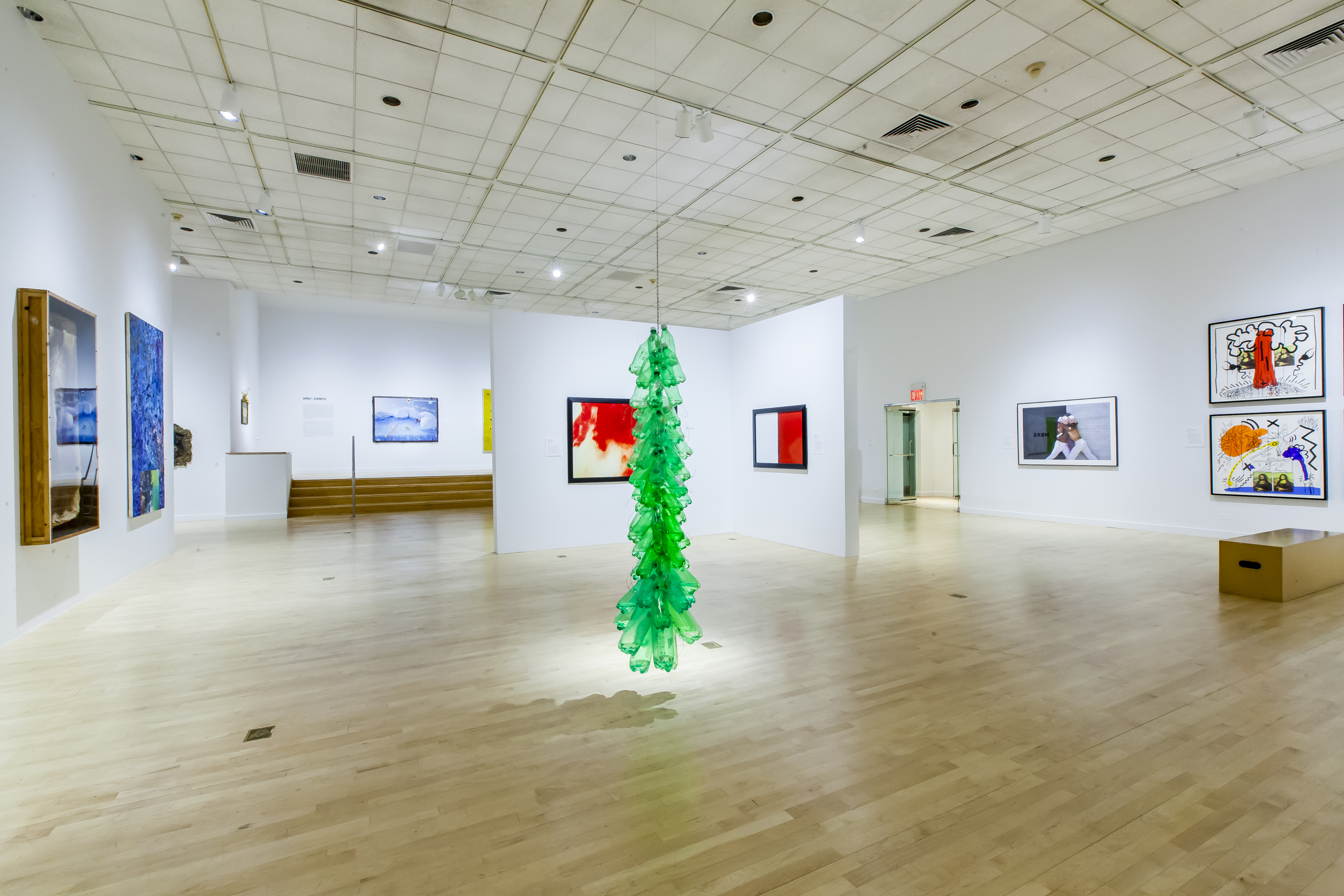 Installation view of Art AIDS America. Center: Tony Feher. Green Window, 2001. Plastic bottles with plastic caps, chain, wire, water, rope, dimensions variable. © Marisol Díaz, 2016.