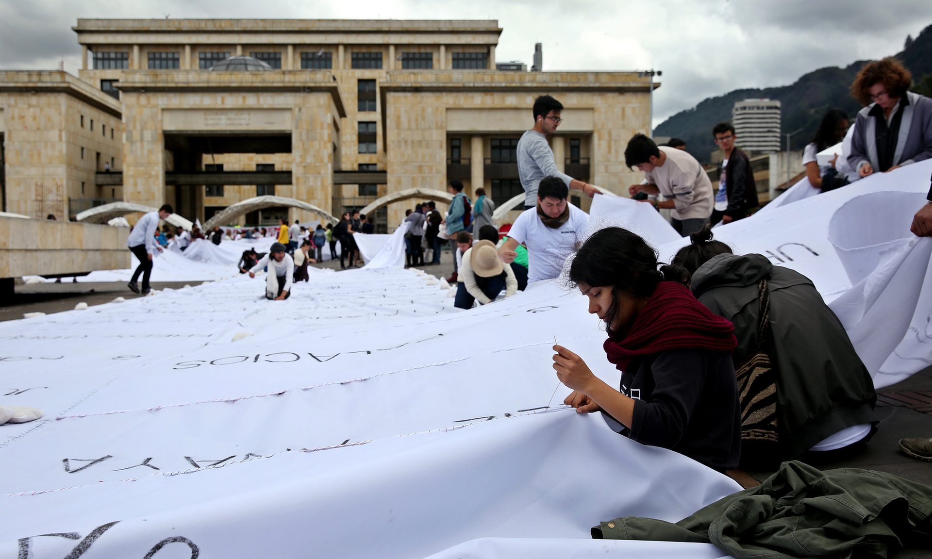  A group of people participate in an artistic intervention lead by the Colombian artist Doris Salcedo in Bogotá on Tuesday. Photograph: Leonardo Muñoz/EPA. Courtesy of the Guardian. 